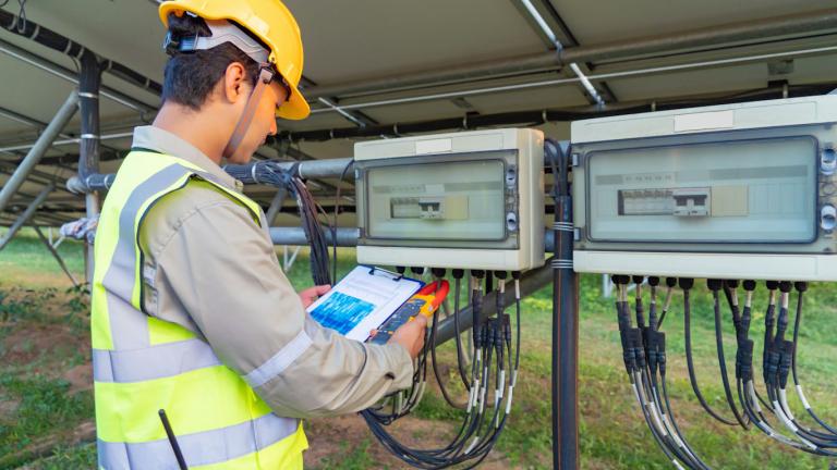 Man checking data on the back of a solar power plant